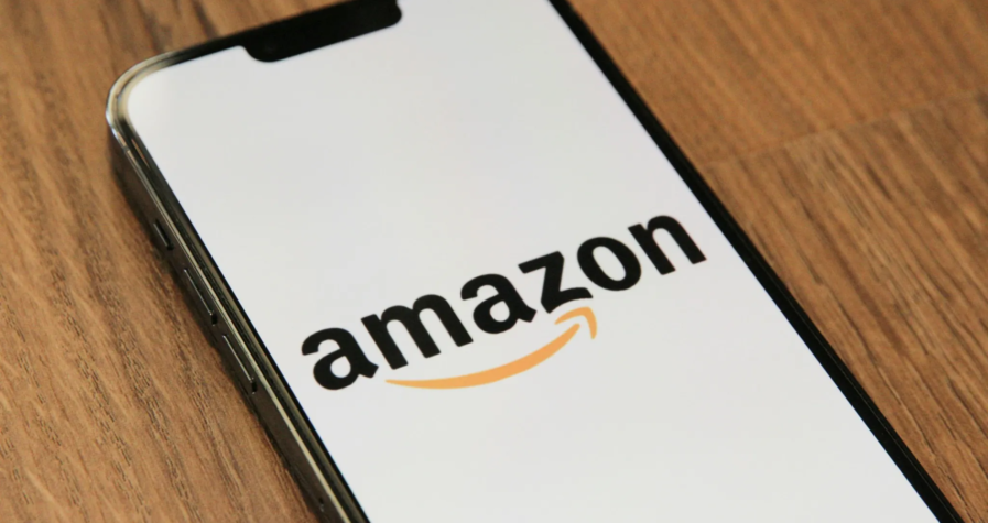 Smartphone displaying the Amazon logo on a wooden surface, highlighting e-commerce and tech branding.