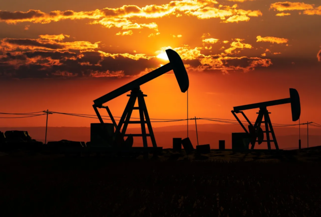 Silhouetted U.S. oil pump jacks at sunset, highlighting energy production and the fuel industry's landscape
